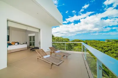 a bedroom with a balcony with a view of the ocean at Ocean-View Villa, Pool & Concierge in Ocotal