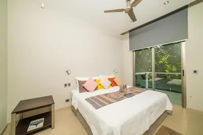 a white bedroom with a bed and a window at Ocean-View Villa, Pool & Concierge in Ocotal
