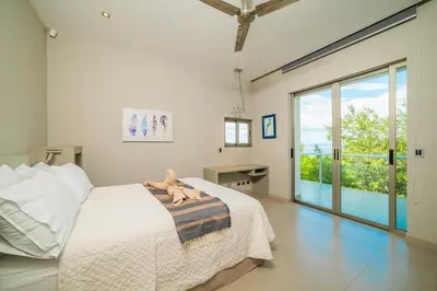 a bedroom with a bed with a stuffed animal on it at Ocean-View Villa, Pool & Concierge in Ocotal