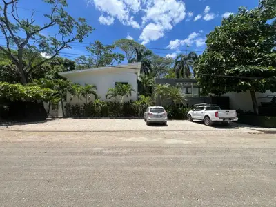 a white house with two cars parked in a parking lot at Garden View, Patio, Steps to Sand with Pool in Potrero