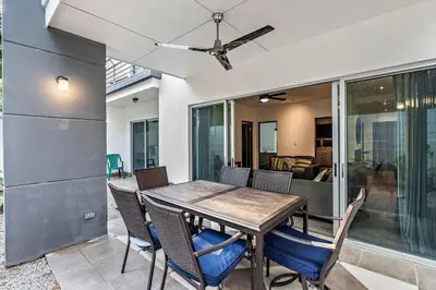 a dining room table with chairs and a ceiling fan at Garden View, Patio, Steps to Sand with Pool in Potrero