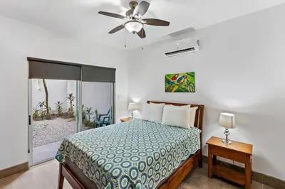 a bedroom with a bed and a ceiling fan at Garden View, Patio, Steps to Sand with Pool in Potrero