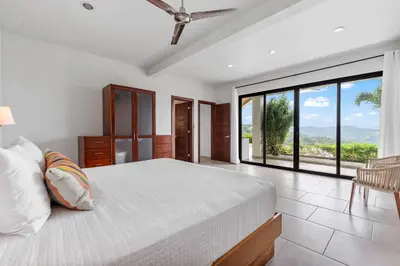 a bedroom with a bed and a large window at Infinity Pool Haven, Ocean Views & Concierge in Potrero