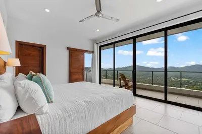 a bedroom with a bed and large glass windows at Infinity Pool Haven, Ocean Views & Concierge in Potrero