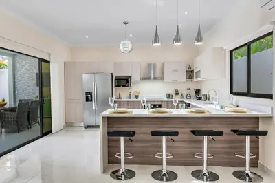 a kitchen with a large island with bar stools at Fun Packed Family Vacation in Playa Flamingo