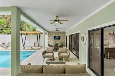 a living room with a couch and a pool at Fun Packed Family Vacation in Playa Flamingo