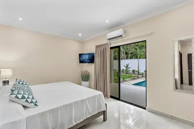 a white bedroom with a bed and a pool at Fun Packed Family Vacation in Playa Flamingo