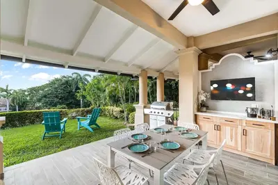 a patio with a table and chairs and a television at Ocean-View Oasis , Swim-Up Bar & Beach Access in Tamarindo