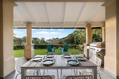 a wooden table and chairs on a patio at Ocean-View Oasis , Swim-Up Bar & Beach Access in Tamarindo
