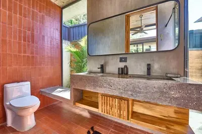 a bathroom with a sink and a toilet and a mirror at Buho Vibe Earthy Elegance in Tamarindo