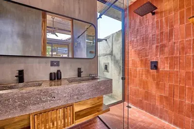 a bathroom with a sink and a mirror and a shower at Buho Vibe Earthy Elegance in Tamarindo