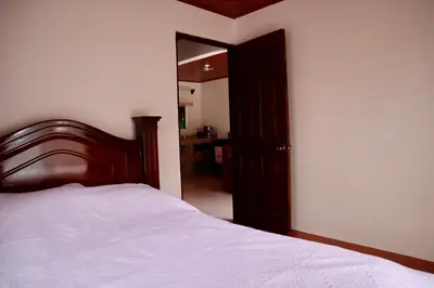 a bedroom with a bed and a door to a hallway at Casa las Orquideas Atenas in Barrio Jesús