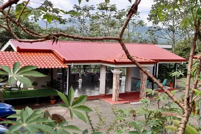 a house with a red roof in a forest at Casa las Orquideas Atenas in Barrio Jesús