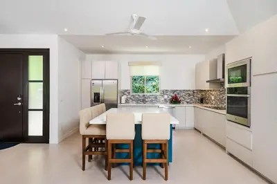 a white kitchen with a table and chairs in it at Exclusive Villa in Mar Vista Community in Playa Flamingo