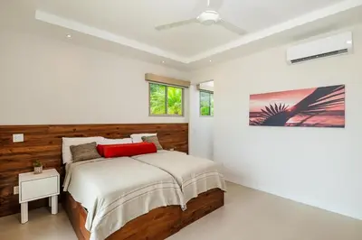 a bedroom with a bed with a red pillow at Exclusive Villa in Mar Vista Community in Playa Flamingo
