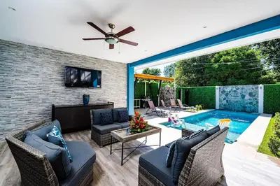 a living room with a pool and a ceiling fan at Private Pool Ping-Pong Table Walk to Beach Villa in Playa Flamingo