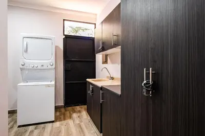 a small kitchen with a sink and a washer and dryer at Private Pool Ping-Pong Table Walk to Beach Villa in Playa Flamingo