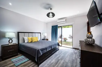 a bedroom with a bed and a flat screen tv at Private Pool Ping-Pong Table Walk to Beach Villa in Playa Flamingo