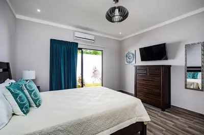 a bedroom with a large bed and a television at Private Pool Ping-Pong Table Walk to Beach Villa in Playa Flamingo