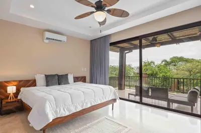 a bedroom with a large bed and a balcony at Hilltop Haven with Pool, Terrace and Sea Breeze in Ocotal