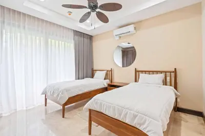a bedroom with two beds and a ceiling fan at Hilltop Haven with Pool, Terrace and Sea Breeze in Ocotal