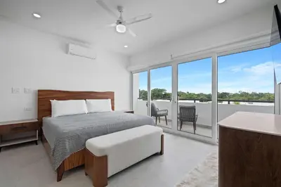 a white bedroom with a bed and a balcony at Modern Villa 5 BD 4 BA Large Pool in Playa Avellana