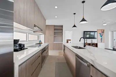 a kitchen with white counter tops and wooden cabinets at Modern Villa 5 BD 4 BA Large Pool in Playa Avellana