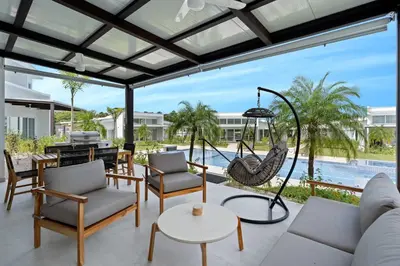 a living room with a swing and a pool at Modern Villa 5 BD 4 BA Large Pool in Playa Avellana