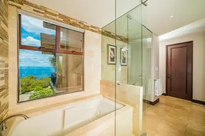 a bathroom with a bath tub and a window at Captivating Ocean Views Condo with Pool in Ocotal