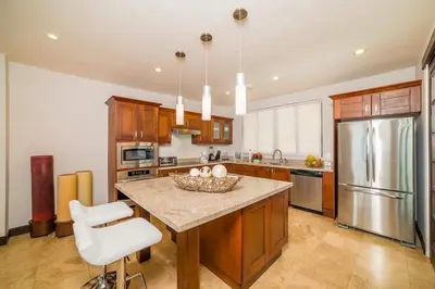a kitchen with a island with a bowl of fruit on it at Captivating Ocean Views Condo with Pool in Ocotal