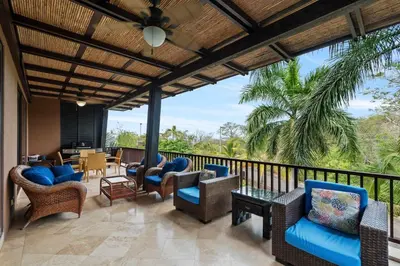 a patio with chairs and tables on a balcony at Spacious 4 Bedroom Condo Pool in Ocotal