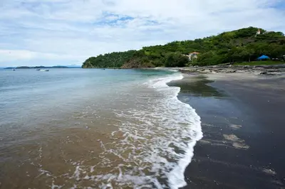 a beach with the tide coming in from the ocean at Spacious 4 Bedroom Condo Pool in Ocotal
