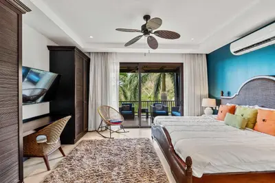 a bedroom with a bed and a ceiling fan at Spacious 4 Bedroom Condo Pool in Ocotal