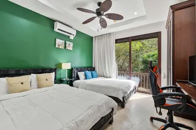 a bedroom with two beds and a green wall at Spacious 4 Bedroom Condo Pool in Ocotal