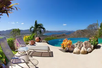 a patio with two chairs and a swimming pool at Luxury Villa, Infinity Pool & Ocean Views in Potrero
