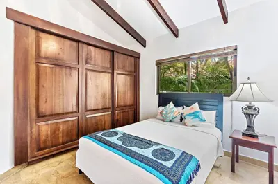 a bedroom with a bed and a large wooden cabinet at Spacious Villa Retreat in Private Resort in Playa Hermosa