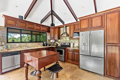a kitchen with wooden cabinets and stainless steel appliances at Spacious Villa Retreat in Private Resort in Playa Hermosa