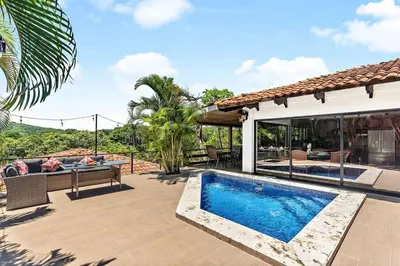 a backyard with a swimming pool and a house at Spacious Villa Retreat in Private Resort in Playa Hermosa