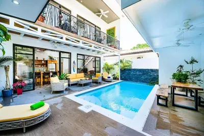 an indoor swimming pool in a house with a patio at Pool Paradise Steps from Beach & Restaurants in Playa Flamingo