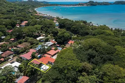 an aerial view of a resort with the beach and trees at Pool Paradise Steps from Beach & Restaurants in Playa Flamingo