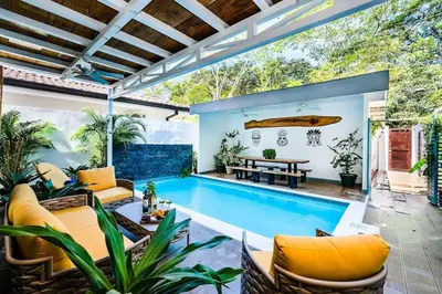 an outdoor patio with a pool and a table and chairs at Pool Paradise Steps from Beach & Restaurants in Playa Flamingo