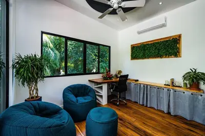 a living room with two blue chairs and a table at Pool Paradise Steps from Beach & Restaurants in Playa Flamingo