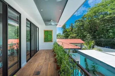 a balcony with a view of a house at Pool Paradise Steps from Beach & Restaurants in Playa Flamingo