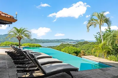 a group of lounge chairs sitting next to a swimming pool at Spectacular Ocean Views Infinity Pool in Potrero