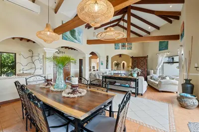 a kitchen and living room with a wooden table and chairs at Spacious Villa with Infinity Pool & Ocean View in Potrero