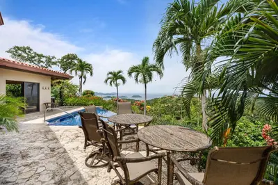 a patio with tables and chairs and a swimming pool at Spacious Villa with Infinity Pool & Ocean View in Potrero