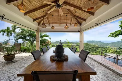 a large wooden table on a patio with a view at Spacious Villa with Infinity Pool & Ocean View in Potrero