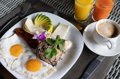 a plate of breakfast food with eggs and a cup of coffee at Tifakara by the Waterfall in Fortuna