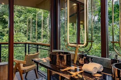 a screened in porch with a table and chairs and windows at Tifakara by the Waterfall in Fortuna