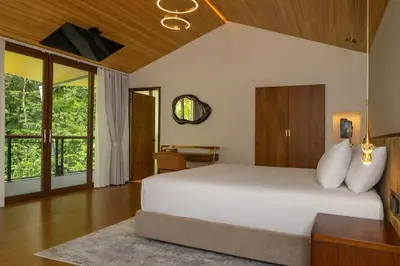 a bedroom with a white bed and a desk at Tifakara by the Waterfall in Fortuna
